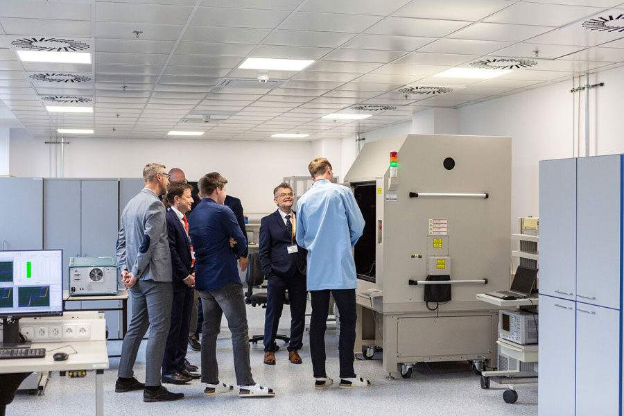 A group of people standing close together and talking to each other.